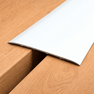Extra wide 80mm self-adhesive aluminium floor transition strip installed between same-level laminate flooring