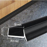Black PVC plinth sealing strip installed on a kitchen kickboard, with dimensions 20.5mm x 18mm x 6mm for moisture and dirt protection.